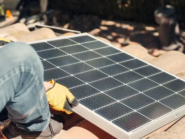 Solar panels on a house roof under a clear sky